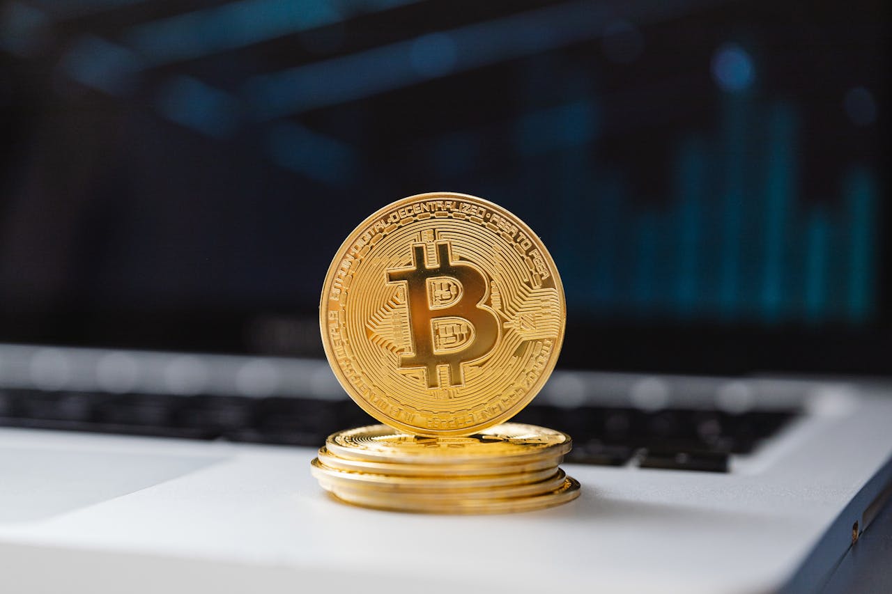 Services A shiny gold Bitcoin coin on laptop keyboard, symbolizing digital currency and blockchain technology.