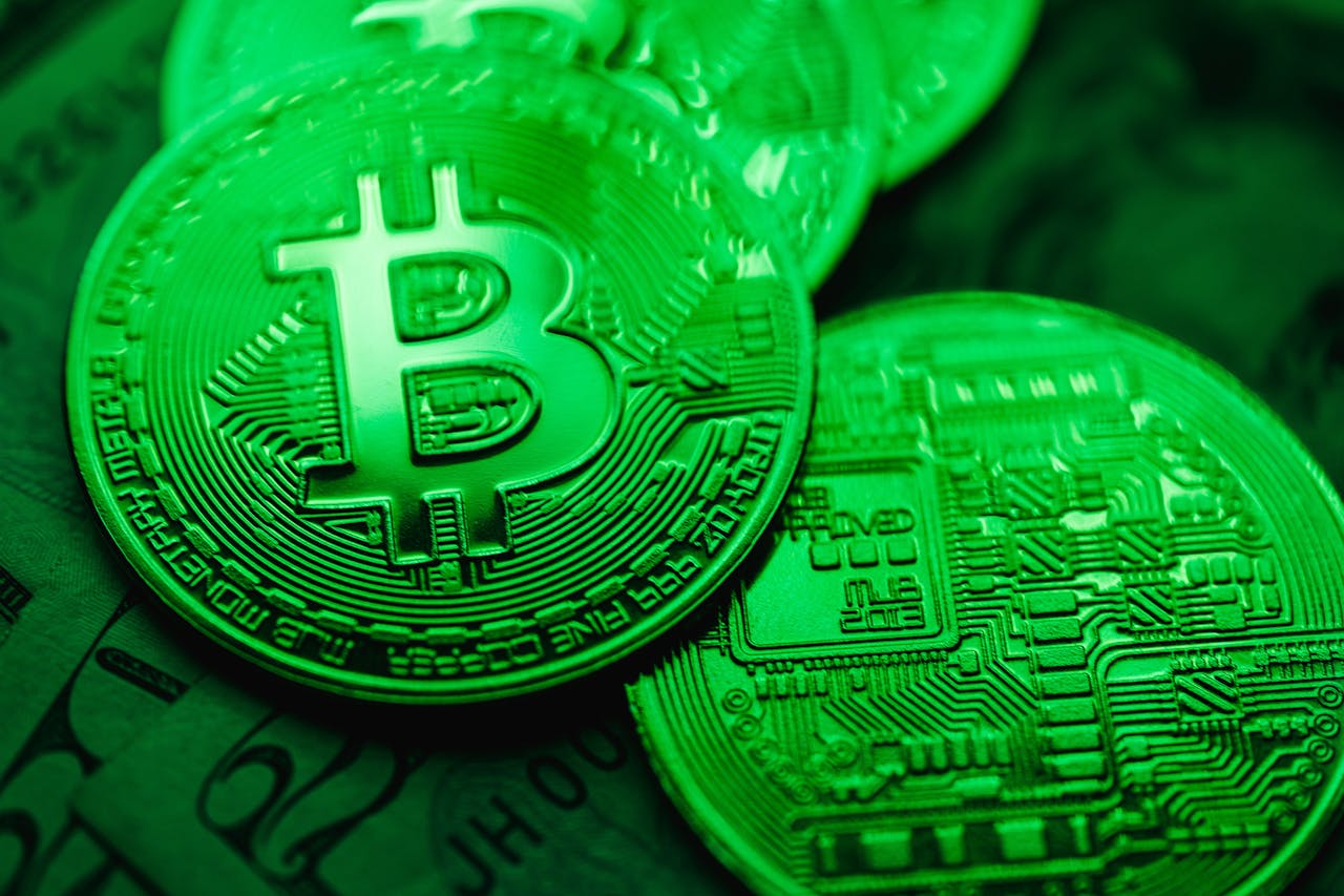 Services Close-up of green-illuminated Bitcoin coins representing digital currency and blockchain technology.